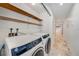 Functional laundry area with washer, dryer, and shelving at 2309 Cypress Walk Way, Ruskin, FL 33570