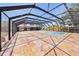 Screened pool is surrounded by travertine tile and overlooks the home's exterior at 2309 Cypress Walk Way, Ruskin, FL 33570