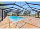 Screened pool, surrounded by travertine tile, overlooks the expansive outdoor area at 2309 Cypress Walk Way, Ruskin, FL 33570