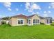 A well maintained backyard with green grass, and a door leading to the sunroom at 26338 Whirlaway Ter, Wesley Chapel, FL 33544