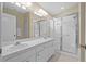 Bright bathroom with neutral walls, double sinks, large mirror and shower with glass doors at 26338 Whirlaway Ter, Wesley Chapel, FL 33544