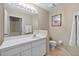 Bathroom with white vanity, tile floors and large mirror at 26338 Whirlaway Ter, Wesley Chapel, FL 33544