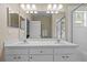 Bright bathroom features neutral walls, double sinks, large mirror, shower with glass doors at 26338 Whirlaway Ter, Wesley Chapel, FL 33544