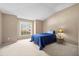 Bright bedroom with large window, blue bed and carpet floors at 26338 Whirlaway Ter, Wesley Chapel, FL 33544