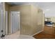 Hallway with tile floors leading to bathroom and hardwood floors to living room at 26338 Whirlaway Ter, Wesley Chapel, FL 33544