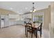 Bright eat-in kitchen with white cabinets, tile floors and stainless refrigerator at 26338 Whirlaway Ter, Wesley Chapel, FL 33544