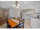 Bright kitchen and dining area with tile floors, white appliances, and a classic chandelier at 26338 Whirlaway Ter, Wesley Chapel, FL 33544