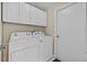 Laundry room with white washer and dryer and white cabinets at 26338 Whirlaway Ter, Wesley Chapel, FL 33544