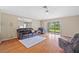 Bright living room with hardwood floors, ceiling fan, and sliding glass doors to a screened patio at 26338 Whirlaway Ter, Wesley Chapel, FL 33544