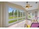 Relaxing sunroom with tile floor, windows, ceiling fan, and door to backyard at 26338 Whirlaway Ter, Wesley Chapel, FL 33544