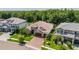 An aerial view of a home with brick driveway, three-car garage, manicured landscaping, and tile roof at 29118 Picana Ln, Wesley Chapel, FL 33543