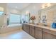 Bathroom boasts a soaking tub, double sink vanity with granite counters, and an abundance of natural light at 29118 Picana Ln, Wesley Chapel, FL 33543