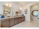 Bathroom features a double vanity with granite countertop, ample storage, and large framed mirrors at 29118 Picana Ln, Wesley Chapel, FL 33543
