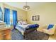 Bedroom with a ceiling fan, large window, a bed with a blue blanket, and art on the wall at 29118 Picana Ln, Wesley Chapel, FL 33543