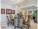 Elegant dining room featuring tray ceilings, modern light fixture, stylish seating, and artwork at 29118 Picana Ln, Wesley Chapel, FL 33543