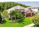 Beautiful home with a manicured lawn, lush landscaping, and a stone facade at 29118 Picana Ln, Wesley Chapel, FL 33543