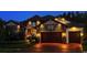 A beautiful home's facade is illuminated at night, accentuating the stonework and landscaping at 29118 Picana Ln, Wesley Chapel, FL 33543