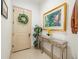 Inviting foyer with a decorative wreath, console table with floral decor, and neutral wall tones at 29118 Picana Ln, Wesley Chapel, FL 33543