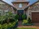 Close-up of the home's entry featuring a decorative front door and stone facade at 29118 Picana Ln, Wesley Chapel, FL 33543