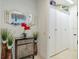 Bright hallway featuring a stylish mirror, cabinet with plants and storage closet at 29118 Picana Ln, Wesley Chapel, FL 33543