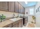 Laundry room with stainless steel appliances, custom cabinets, and granite counters offers functionality and style at 29118 Picana Ln, Wesley Chapel, FL 33543