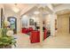 Elegant living room with columns, stone wall, piano, and bright red seating at 29118 Picana Ln, Wesley Chapel, FL 33543