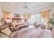 Bright main bedroom with large window, stylish rug, and seating area offers a serene and comfortable space at 29118 Picana Ln, Wesley Chapel, FL 33543