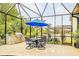 Outdoor dining area features a built-in grill, dining table, and screened-in patio at 29118 Picana Ln, Wesley Chapel, FL 33543