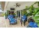 Covered patio features a ceiling fan, stylish furniture, and views of the backyard at 29118 Picana Ln, Wesley Chapel, FL 33543