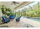 Comfortable screened patio boasts stylish furniture, ceiling fan, and views of the backyard pool at 29118 Picana Ln, Wesley Chapel, FL 33543
