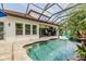 Spacious screened-in pool area with beautiful landscaping, patio, and multiple seating areas at 29118 Picana Ln, Wesley Chapel, FL 33543