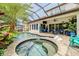 Relaxing pool area features a spa, covered patio, and lush tropical landscaping at 29118 Picana Ln, Wesley Chapel, FL 33543
