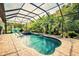 Beautiful pool with spa, lush landscaping, screened enclosure, and stone paver deck at 29118 Picana Ln, Wesley Chapel, FL 33543