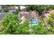 Aerial view of a home showcasing the roof, mature trees, and inviting screened-in pool area at 2973 Spring Oak Ct, Palm Harbor, FL 34684