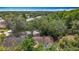 Aerial view of a home with a screened pool surrounded by mature trees in a residential neighborhood at 2973 Spring Oak Ct, Palm Harbor, FL 34684