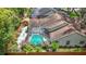 Aerial view of a home with a screened-in pool, landscaped backyard, privacy fence and storage shed at 2973 Spring Oak Ct, Palm Harbor, FL 34684