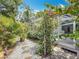 Landscaped backyard with white gravel, stepping stones, foliage, and a screened-in lanai at 2973 Spring Oak Ct, Palm Harbor, FL 34684