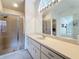 Large bathroom with white vanity with lots of counter space and bright lighting, and glass shower at 2973 Spring Oak Ct, Palm Harbor, FL 34684