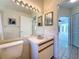 Bright bathroom featuring a pink sink, large mirror with vanity lighting, and tile flooring at 2973 Spring Oak Ct, Palm Harbor, FL 34684