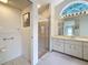 Bright bathroom featuring large vanity, glass enclosed shower, and natural light from transom window at 2973 Spring Oak Ct, Palm Harbor, FL 34684