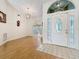 Bright foyer with a decorative glass front door, chandelier, and wood flooring that leads into the living area at 2973 Spring Oak Ct, Palm Harbor, FL 34684