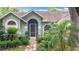 Inviting front entrance with lush tropical landscaping leading to the front door at 2973 Spring Oak Ct, Palm Harbor, FL 34684