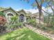 Inviting single-Gathering home with a manicured lawn, mature landscaping, and a brick walkway at 2973 Spring Oak Ct, Palm Harbor, FL 34684