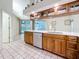 Open-concept kitchen with wood cabinets, quartz countertops, stainless appliances, and access to the pool area at 2973 Spring Oak Ct, Palm Harbor, FL 34684