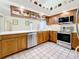 Well-appointed kitchen with modern stainless steel appliances, wooden cabinets, and white countertops for a clean, stylish look at 2973 Spring Oak Ct, Palm Harbor, FL 34684