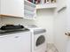 Efficient laundry room with modern washer, dryer and upper cabinets at 2973 Spring Oak Ct, Palm Harbor, FL 34684