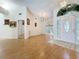 Open-concept living room with wood floors, high ceilings, and an arched window, providing a spacious and airy feel at 2973 Spring Oak Ct, Palm Harbor, FL 34684