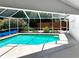 Inviting screened-in pool area featuring cool, refreshing water and ample patio space for entertaining at 2973 Spring Oak Ct, Palm Harbor, FL 34684
