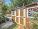 Exterior view of a wooden shed with double doors and a small window at 2973 Spring Oak Ct, Palm Harbor, FL 34684