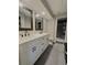 Bathroom featuring a double sink vanity with white cabinets, dark hardware, and tiled floors at 30 Tads Trl, Oldsmar, FL 34677